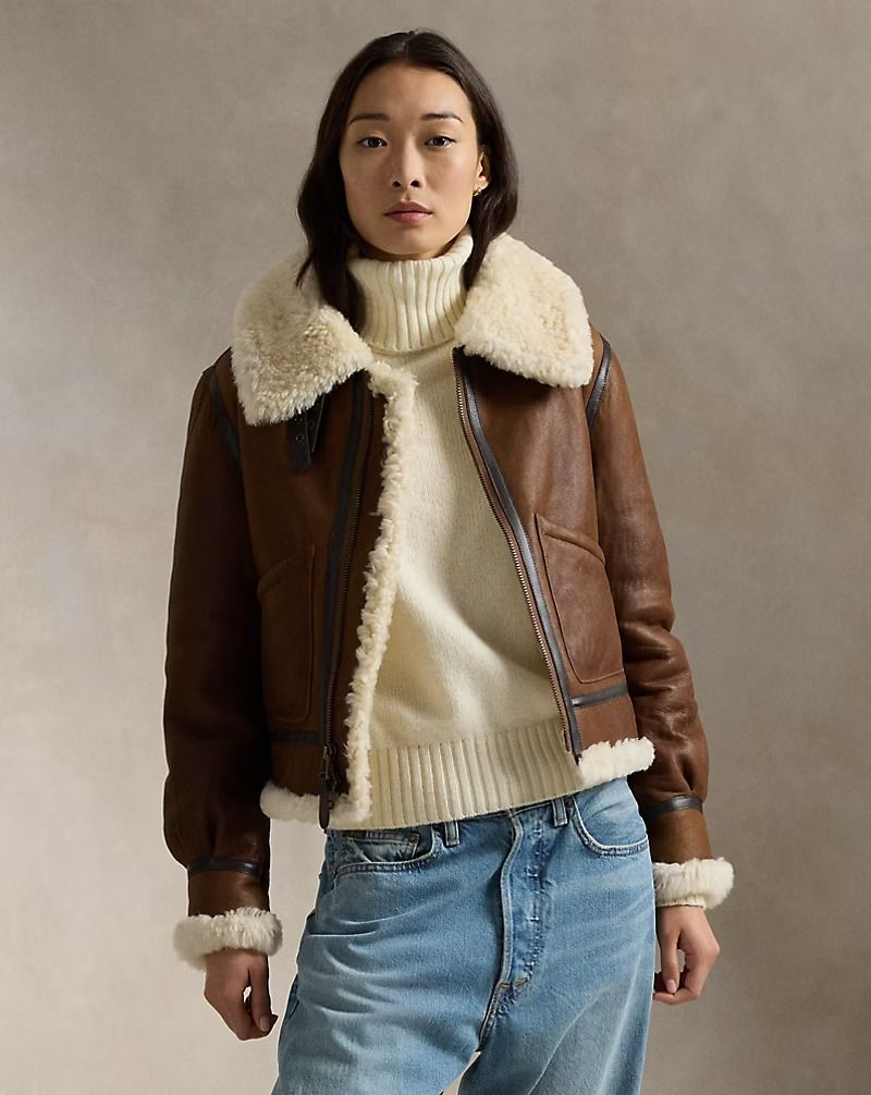 Woman wearing a luxurious shearling leather jacket over a turtleneck sweater, showcasing a stylish and cozy winter outfit