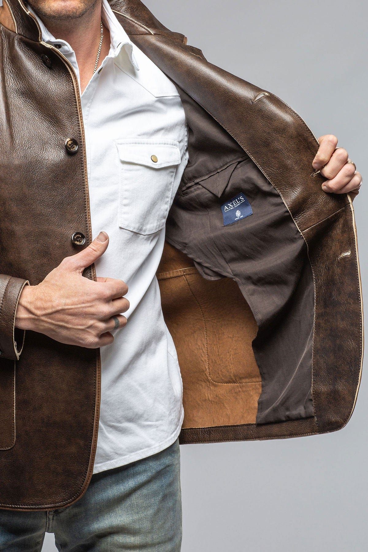 Man holding a leather jacket showing the lining, demonstrating how to clean a leather jacket lining.